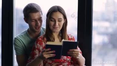 在家里度过美好的时光，美丽的年轻相爱的夫妇彼此联系，微笑着，而女人看书